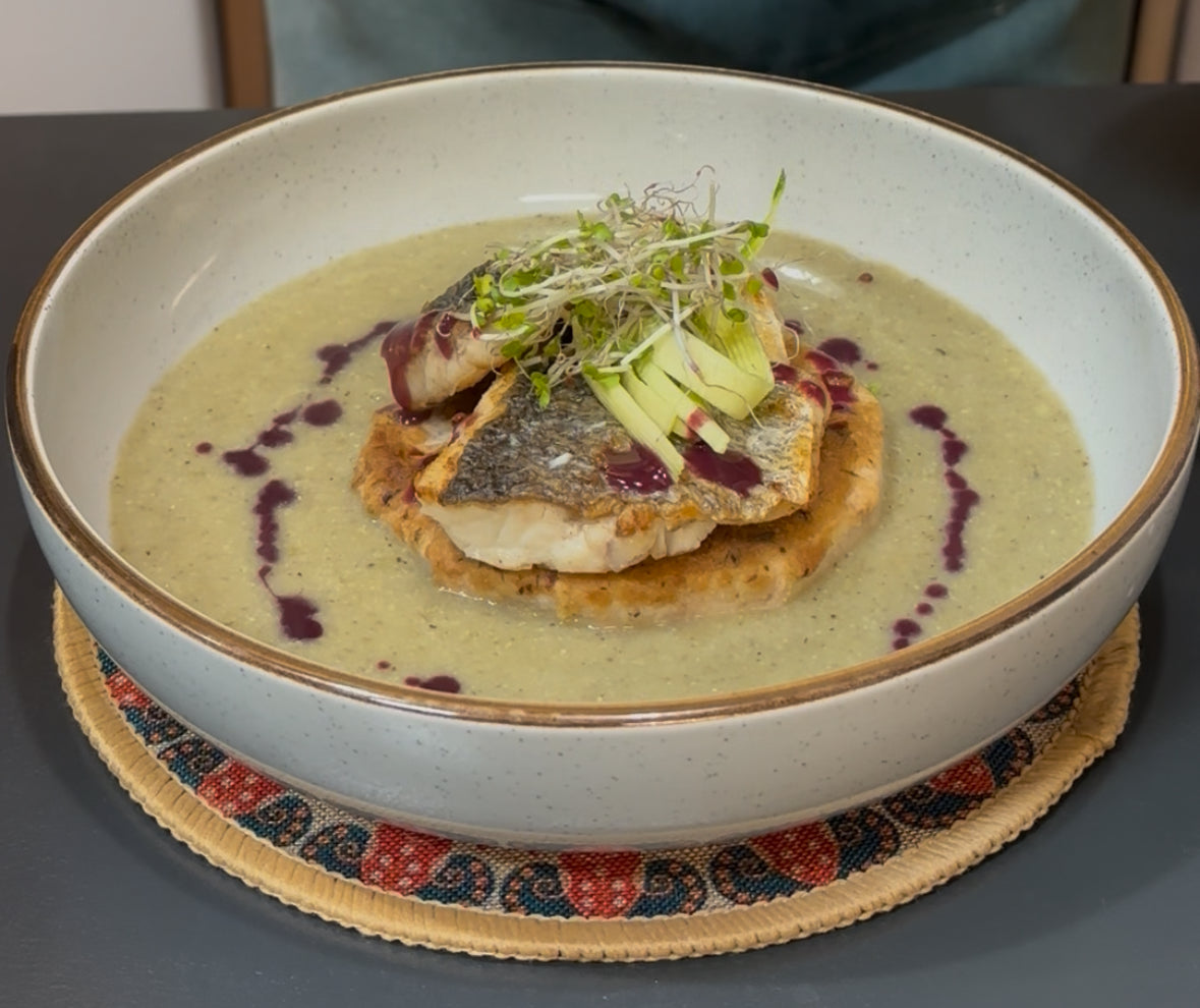 Filet de bar poêlé sur pain de taro frit, servi avec soupe de mil et sauce au bleuet citronnée